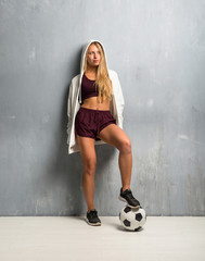 Young sport woman holding a soccer ball