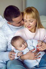 family with son sitting on the bed