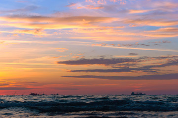 Naklejka na ściany i meble Sunset over the sea. Reflection of sunlight in the sea waves. Red and yellow sky in the rays of the sunset.