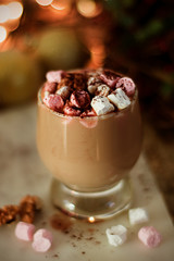 Hot chocolate or cocoa drink, with marshmallows on Christmas background.