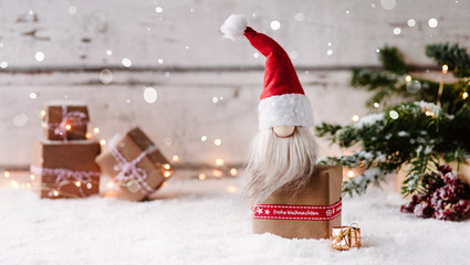 Frohe Weihnachten - Kleiner Weihnachtswichtel sitzt auf einem Geschenk und freut sich auf...