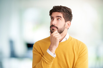 Young businessman look thoughfully while standing indoor