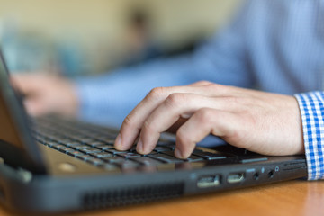 hands typing on laptop keyboard