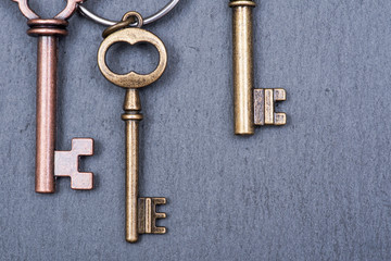 Old vintage metallic keys an natural stone background