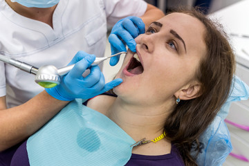 Woman in dentistry making hygiene of teeth