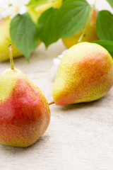 Fresh pears with leaves in a on wooden background.