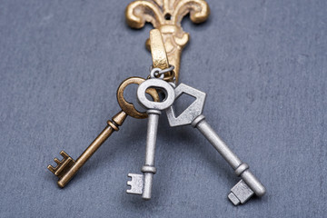 Old vintage metallic keys an natural stone background