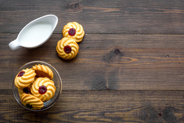 Children tradition evening dessert. Milk and homemade cookies on dark wooden background top view copy space