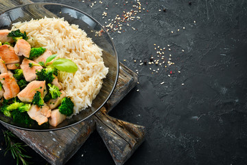 Rice with chicken fillet and vegetables. Top view. On a black background. Free copy space.