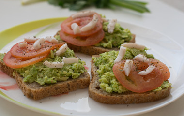 Tomato avocado toast on beautifull plate. Health breakfast or snack concept. Food photography concept. Copy space.