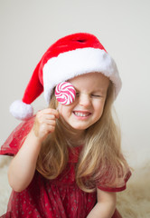 Little Beautiful Girl in Santa Hat Red Party Dress Waiting for Christmas and New Year Indoor Happy