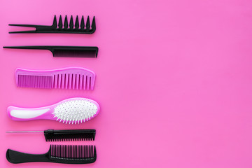 Set of professional hairdresser tools with combs pink background top view mockup