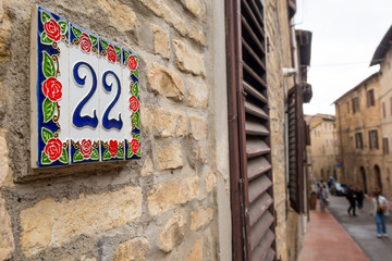 House number written on ceramic plate and placed on building.