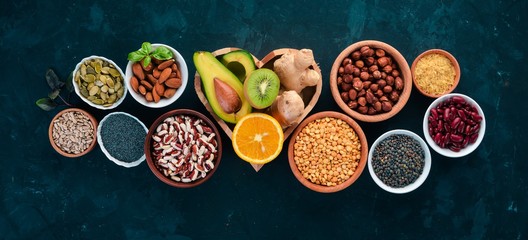 Superfoods Healthy food. Nuts, berries, fruits, and legumes. On a black stone background. Top view. Free copy space.