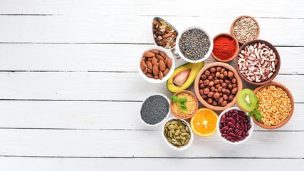 Superfoods Healthy food. Nuts, berries, fruits, and legumes. On a white wooden background. Top view. Free copy space.