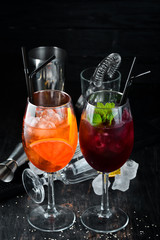 Two alcoholic cocktails. Aperol Sprits, Cocktail with currant. On a wooden background. Top view. Free copy space.