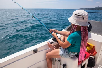 Foto auf Acrylglas One pretty girl have fishing on sailboat, deep-sea fishing trip, holding rod in hands © Kekyalyaynen