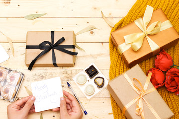 autumn and holiday concept: roses bouquet of flowers and boxes present, woolen scarf, algerian jam...