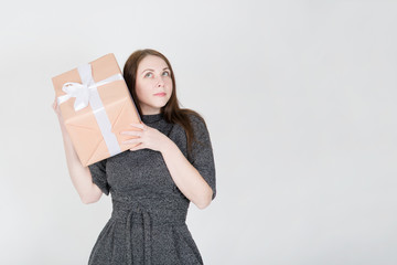 Portrait of a young woman in sunglasses isolated, holding present box