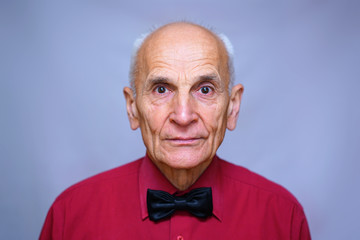  senior old man portrait in red shirt and black bow tie