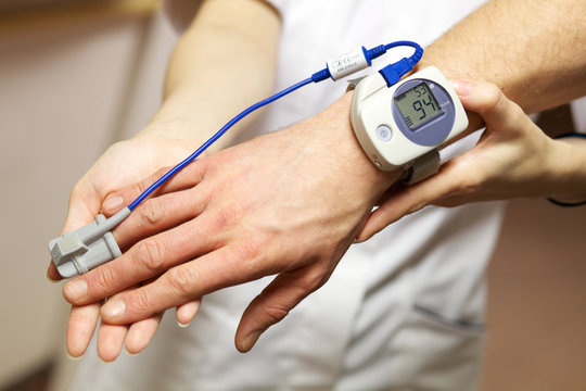 A nurse uses a pulse oximeter to monitor a patients oxygen saturation