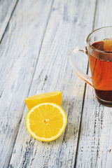Hot black tea and lemon on table