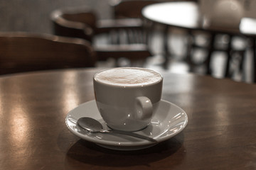 A cup of coffee, espresso or latte. Coffee break. Hot morning drink. Meeting at a coffee shop or cafe. White cup and saucer. White ceramic dishes in the restaurant.