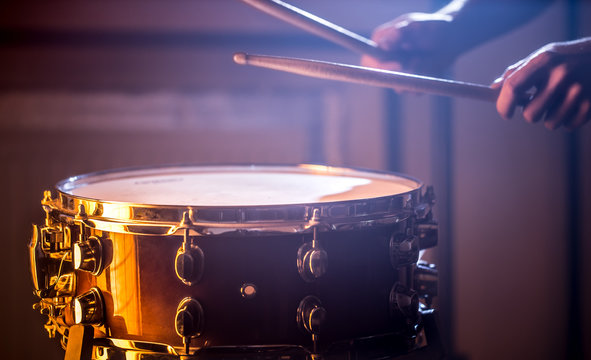 man playing the snare drum on a beautiful colored background
