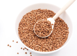 Buckwheat in bowl closeup isolated on white background.