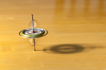 Toy gyroscope spinning and balancing on a wooden table