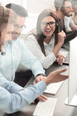 smiling employees of call center talk sitting behind a Desk