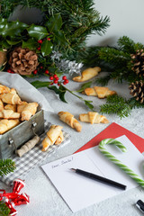 Just Baked Croissant Cookies with Filling in an iron box. Christmas pastries, a wreath, sweets and a letter to Santa Claus. Gray background.