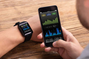 Man With Mobile And Smartwatch Showing Heartbeat Rate