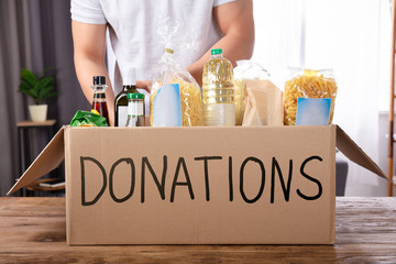 Man Putting Groceries In Donation Box