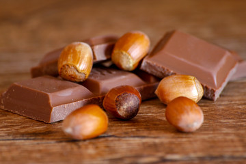Chocolate and hazelnut on wooden table. Close-up photo with vintage background.