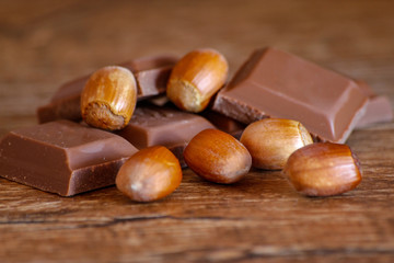 Chocolate and hazelnut on wooden table. Close-up photo with vintage background.