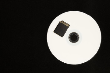 Memory card and digital disc isolated on black background. sd card and cd macro. copy space