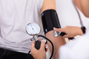 Doctor Measuring Blood Pressure Of Patient