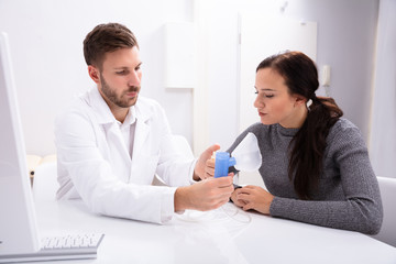 Obraz premium Doctor Giving Information On Using Oxygen Mask To Woman