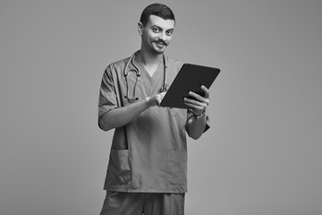 Handsome young arabic doctor with fancy mustache in blue