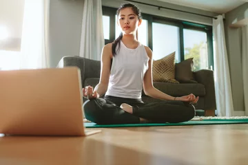 Foto op Aluminium Meisje kijkt naar laptop en doet thuis yoga © Jacob Lund