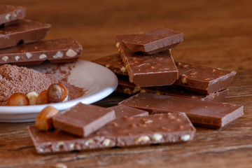 Cocoa, hazelnut and chocolate with hazelnut on wooden table. Close-up photo with vintage background.