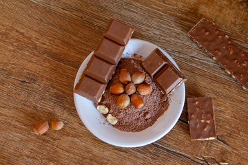 Cocoa, hazelnut and chocolate with hazelnut on wooden table. Close-up photo with vintage background.