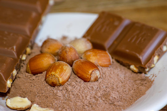Cocoa, hazelnut and chocolate with hazelnut on wooden table. Close-up photo with vintage background.