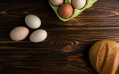 Eggs and bread on wooden table Top view