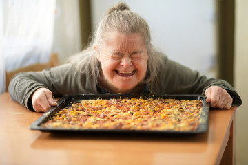 portrait of adult woman with down syndrome holding pizza