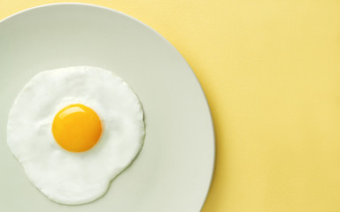 Top view of fried egg on yellow background