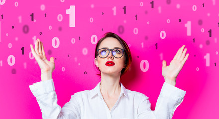 Beautiful redhead businesswoman with one and zero binary code on pink background