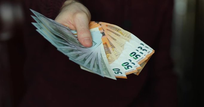 Male hands give me US dollars and euro money