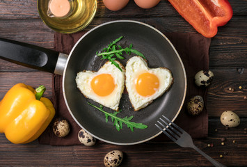 Fried eggs on a skillet on a wooden background